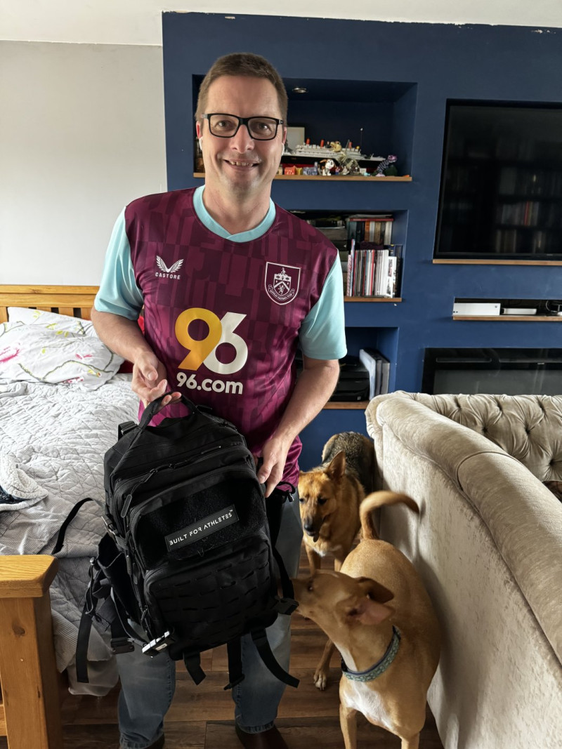 Man in Burnley football shirt leaving house with podencos behind