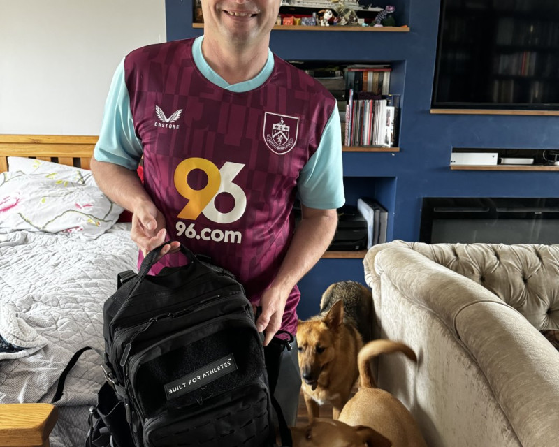 Man in Burnley football shirt leaving house with podencos behind